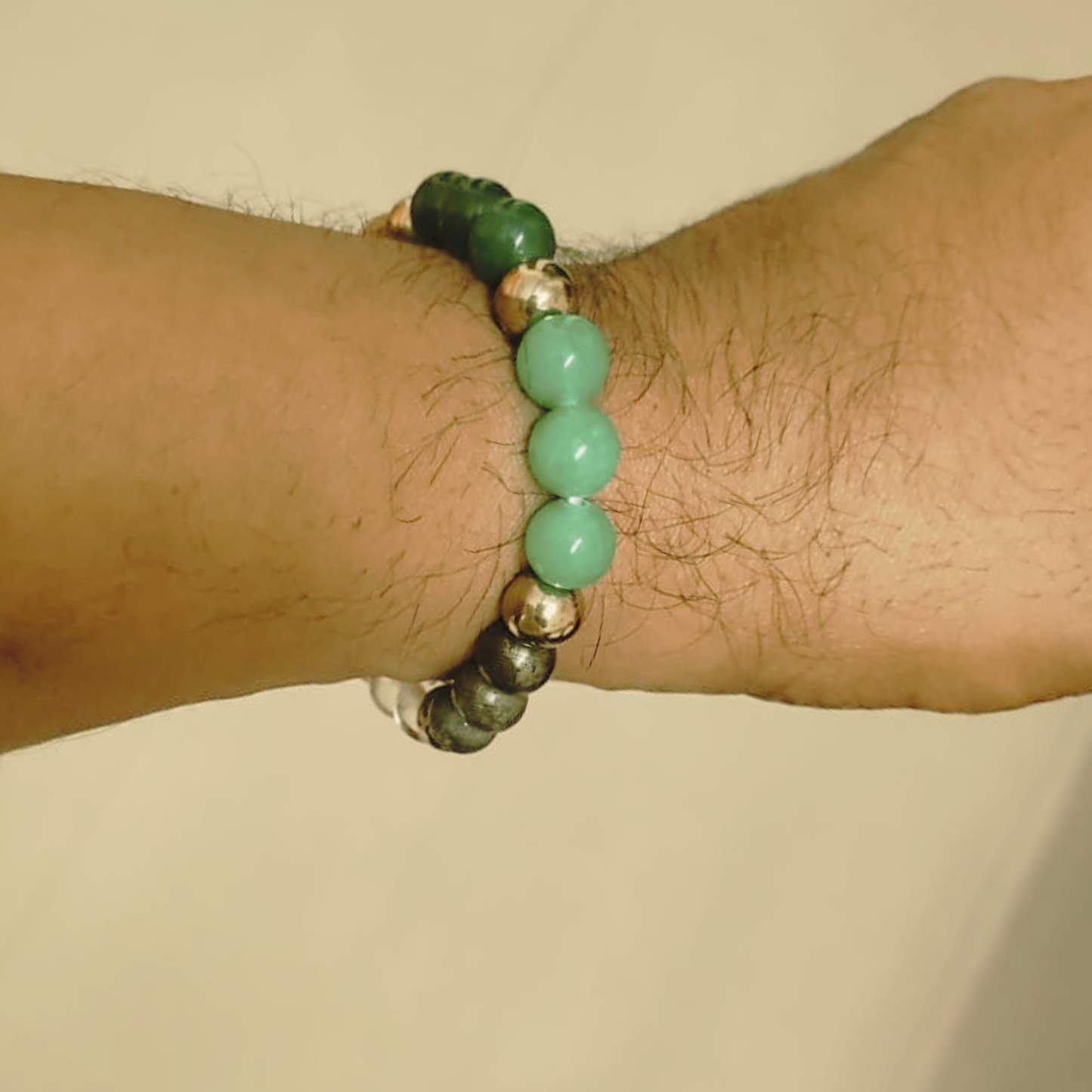 Dhan Yog Bracelet with six Crystal types beads on a wrist against a beige background