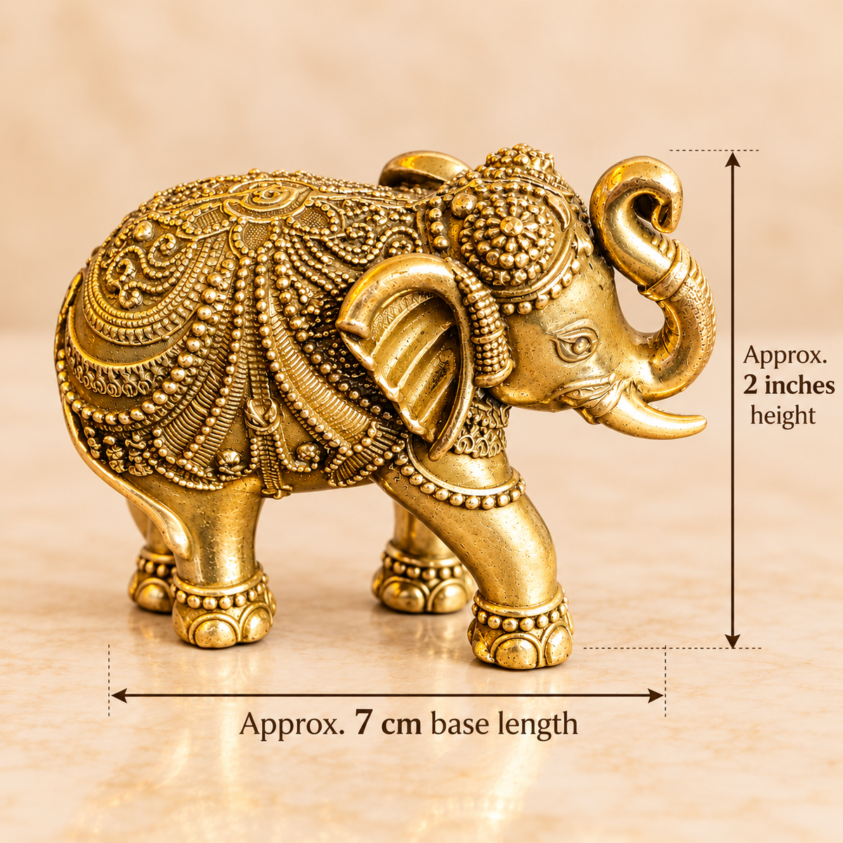Brass elephant figurine with measurement arrows showing approximately 2 inch height and 7 cm length