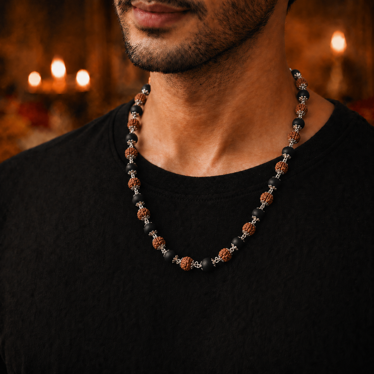 Man wearing a Karungali Rudraksha mala Silver Chain  with a blurred candlelit background