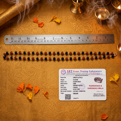 Rudraksha and Karungali silver mala chain with SRT Gems Testing Laboratory label on a textured surface.