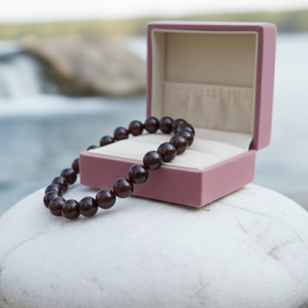 Garnet bracelet draped over an open pink gift box