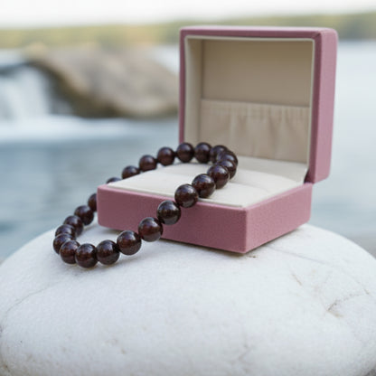 Garnet bracelet draped over an open pink gift box