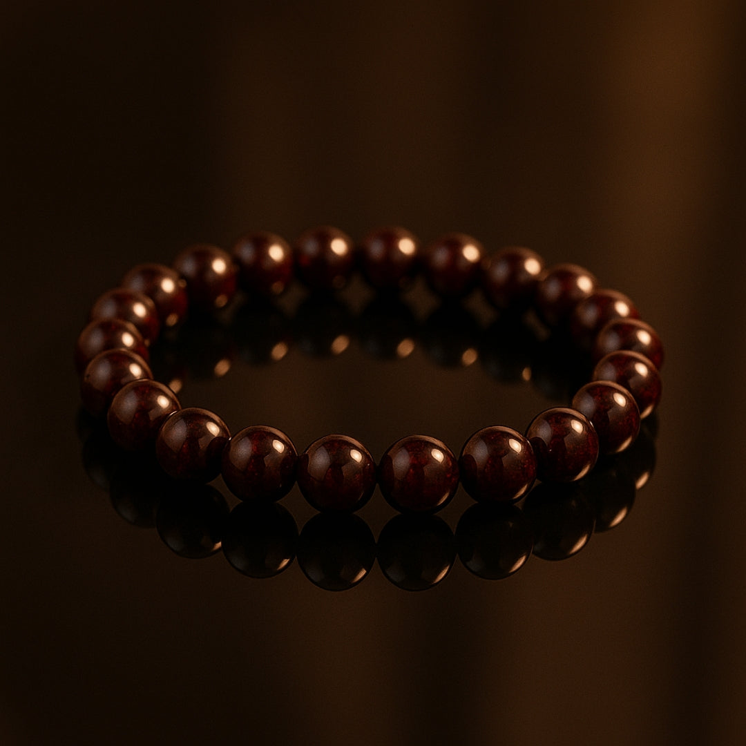Reddish-brown Garnet bracelet on a dark reflective surface