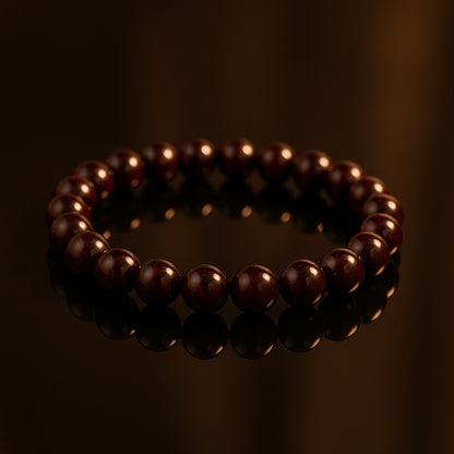 Reddish-brown Garnet bracelet on a dark reflective surface