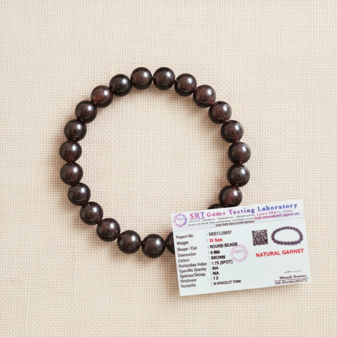 Garnet bracelet beside a gemstone identification card on cream fabric
