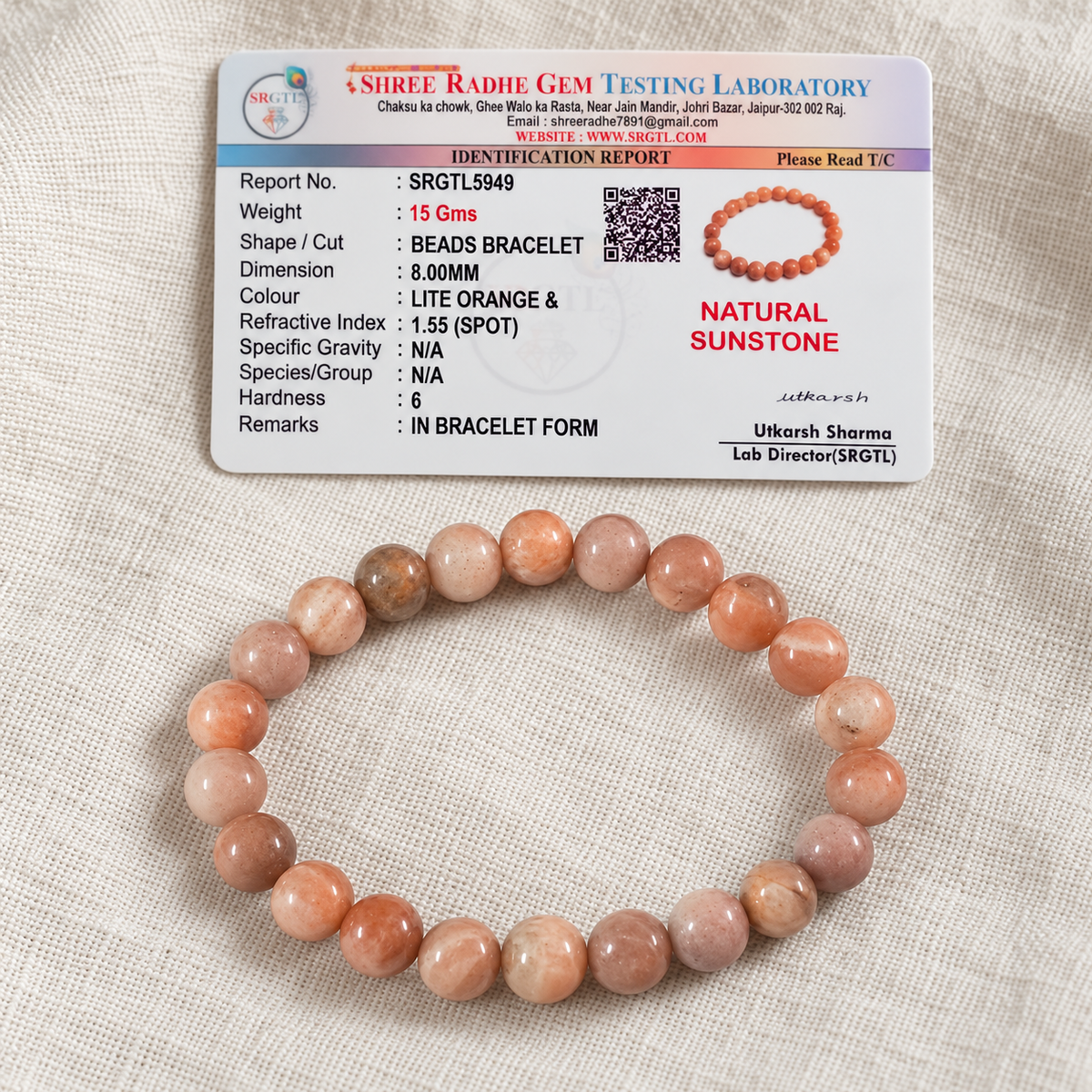 Sunstone bracelet beside a Shree Radhe Gem Testing Laboratory identification report