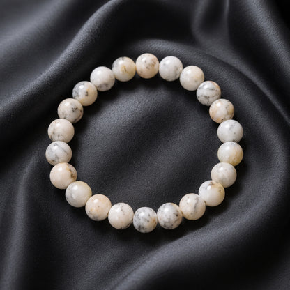 White Opal bead bracelet with darker markings on black fabric